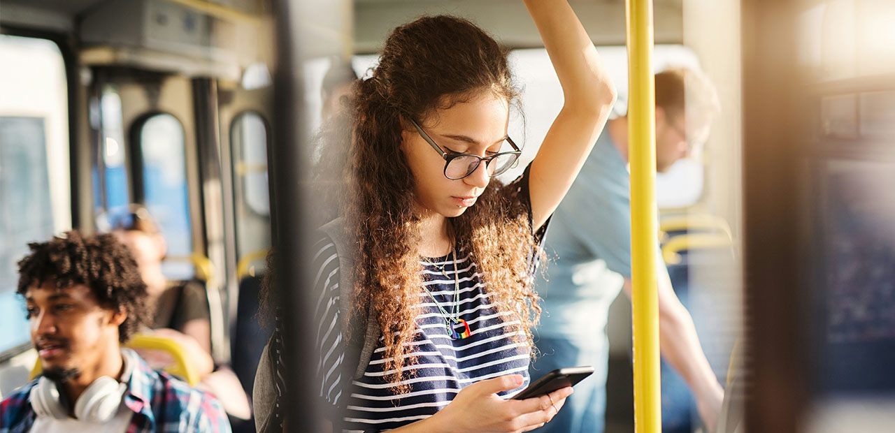 Une jeune fille sur son smartphone, dans un bus.