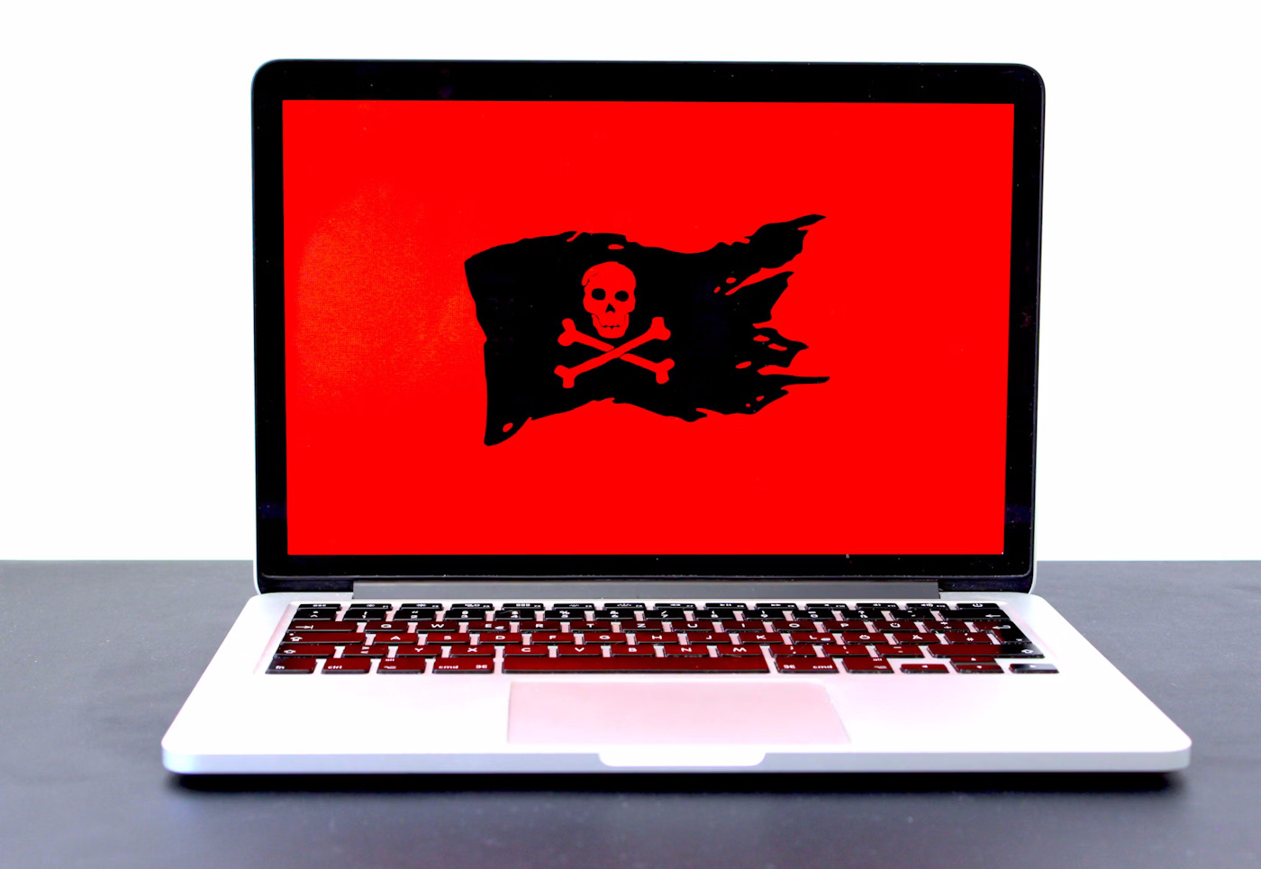 Un ordinateur avec un drapeau pirate sur fond rouge